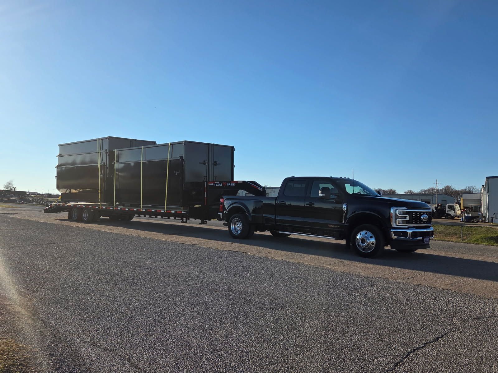 Pickup truck towing a Triple R Dump trailer loaded with roll-off bins